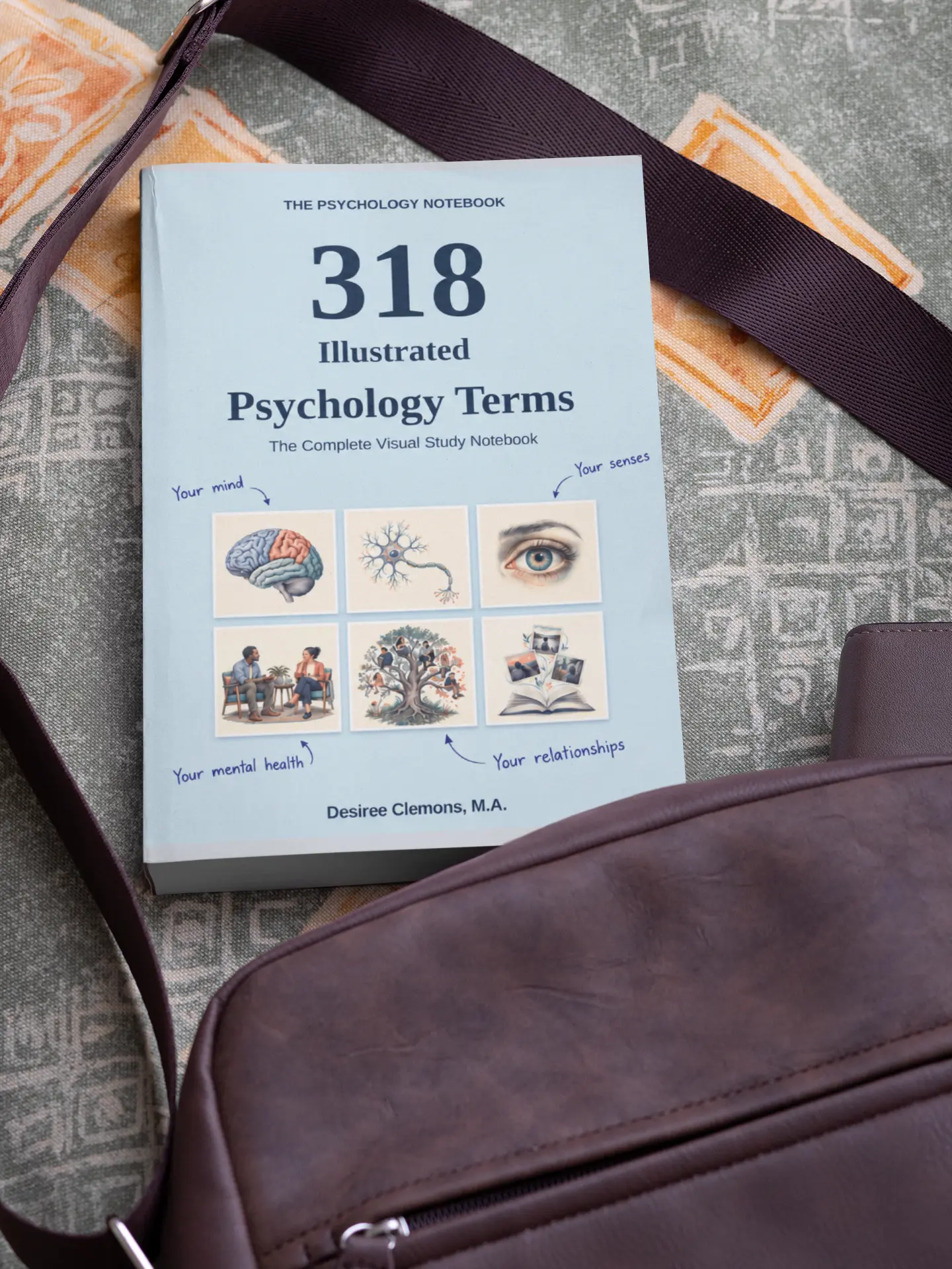 318 Illustrated Psychology Terms paperback beside a shoulder bag